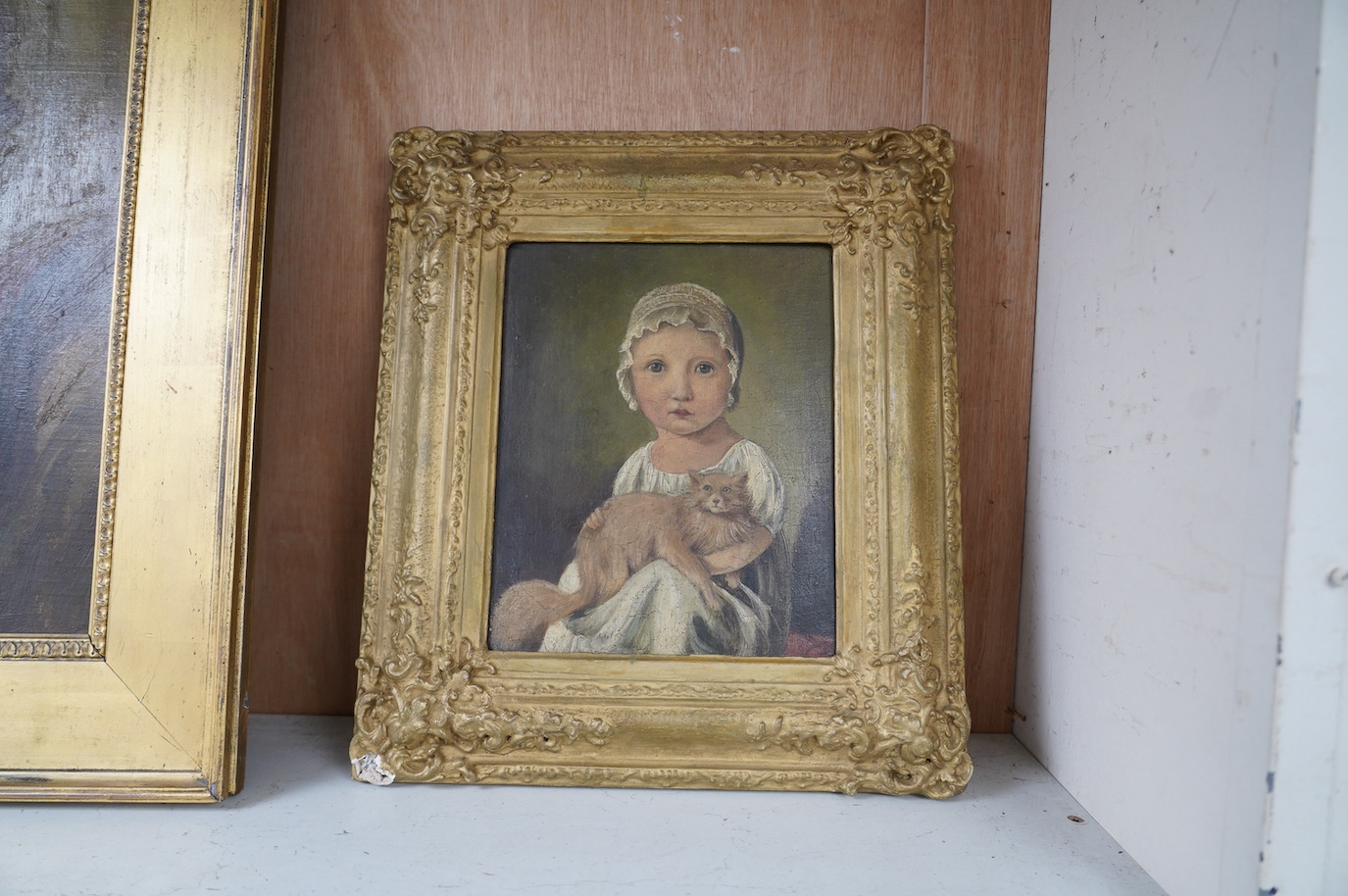 Early 19th naive School, oil on board, Study of a young girl with a cat, 24 x 20cm, ornate gilt frame. Condition - fair